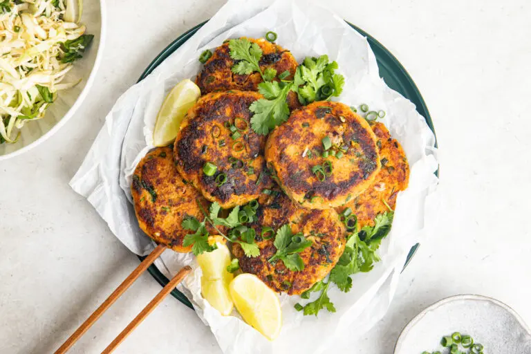 Thai sweet potato fish cakes with coriander, spring onions and lemon wedges.