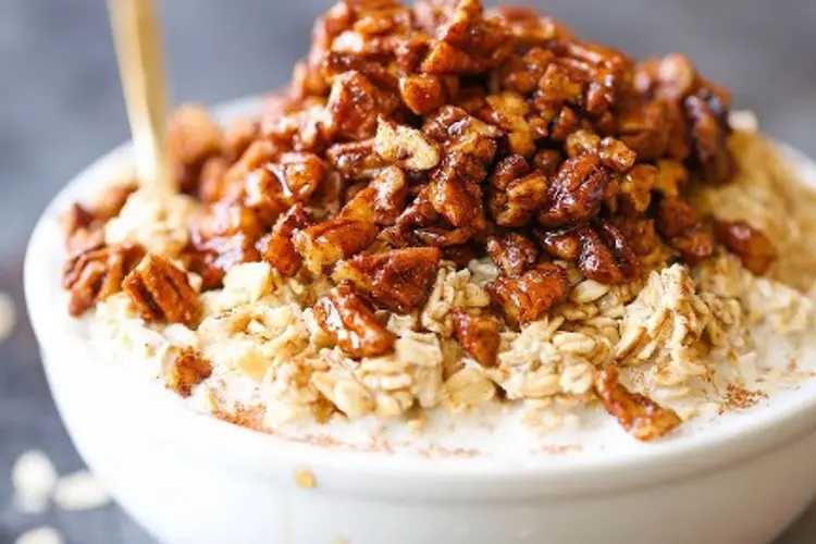 Pecan pie overnight oats recipes served in a bowl, studded with pecan halves and a light caramel swirl