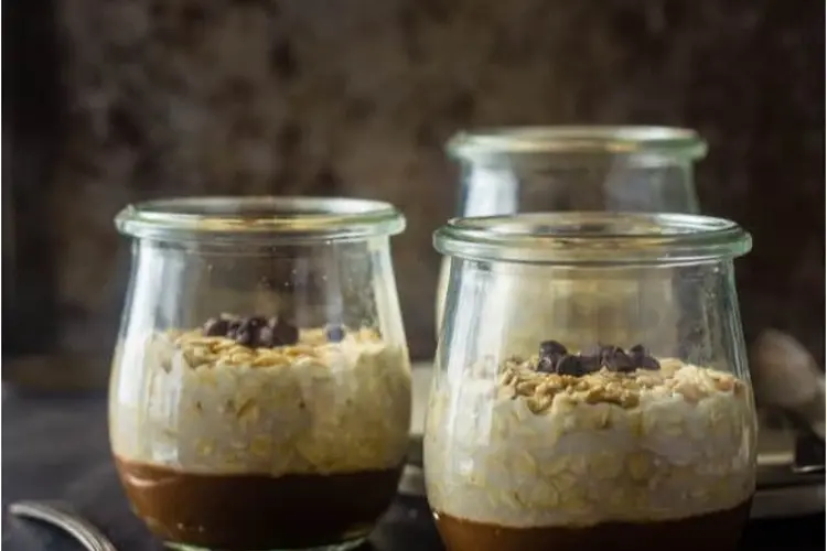 Vegan chocolate overnight oats recipes in a jar, rich and chocolate-coloured, topped with cacao nibs