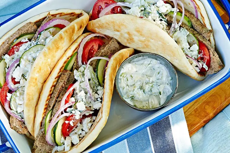 A soft flatbread filled with spiced minced beef, fresh salad, and creamy tzatziki, a Greek-style beef mince recipe.