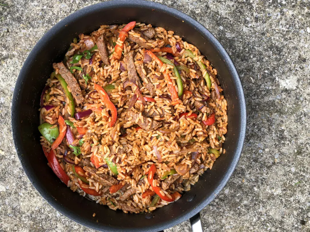 Sizzling fajita steak with peppers and rice, a Tex-Mex inspired low calorie meal prep dish full of punch.