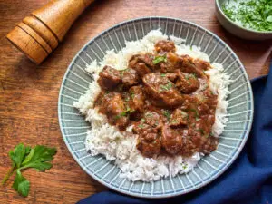 Tender and aromatic slow cooker beef stifado—a rich, flavourful high-protein beef recipe! Perfect for high-protein recipes, meal prep, and hearty dinners.