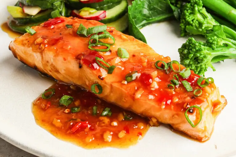 Glazed salmon fillet coated in sweet chilli sauce, topped with spring onion slices.