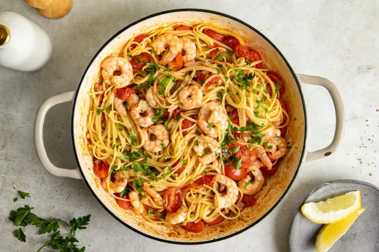 High-protein prawn linguine with chorizo, cherry tomatoes and fresh parsley in a cooking pan.