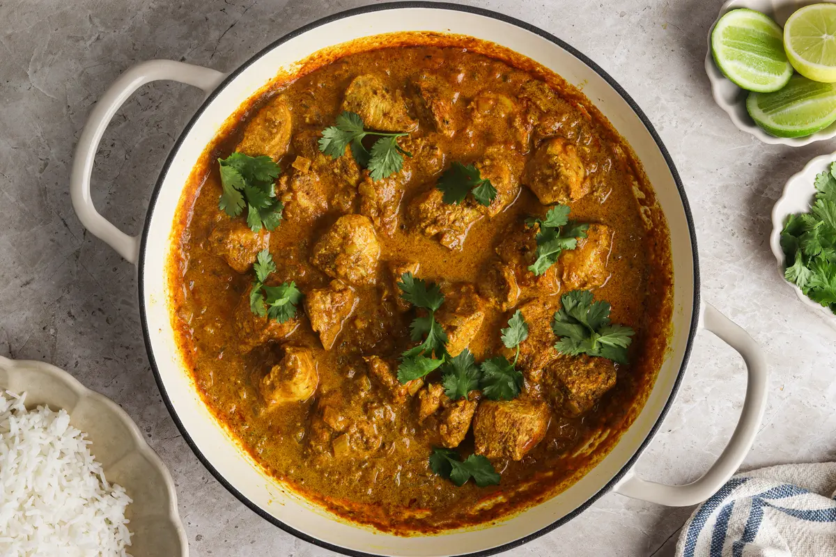 Large pot of cooked Sri Lankan chicken curry with visible coriander and vibrant coconut sauce