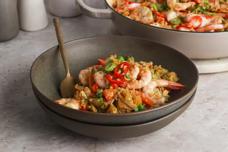 Bowl of Singapore Fried Rice with prawns, vegetables, and curry-spiced rice.