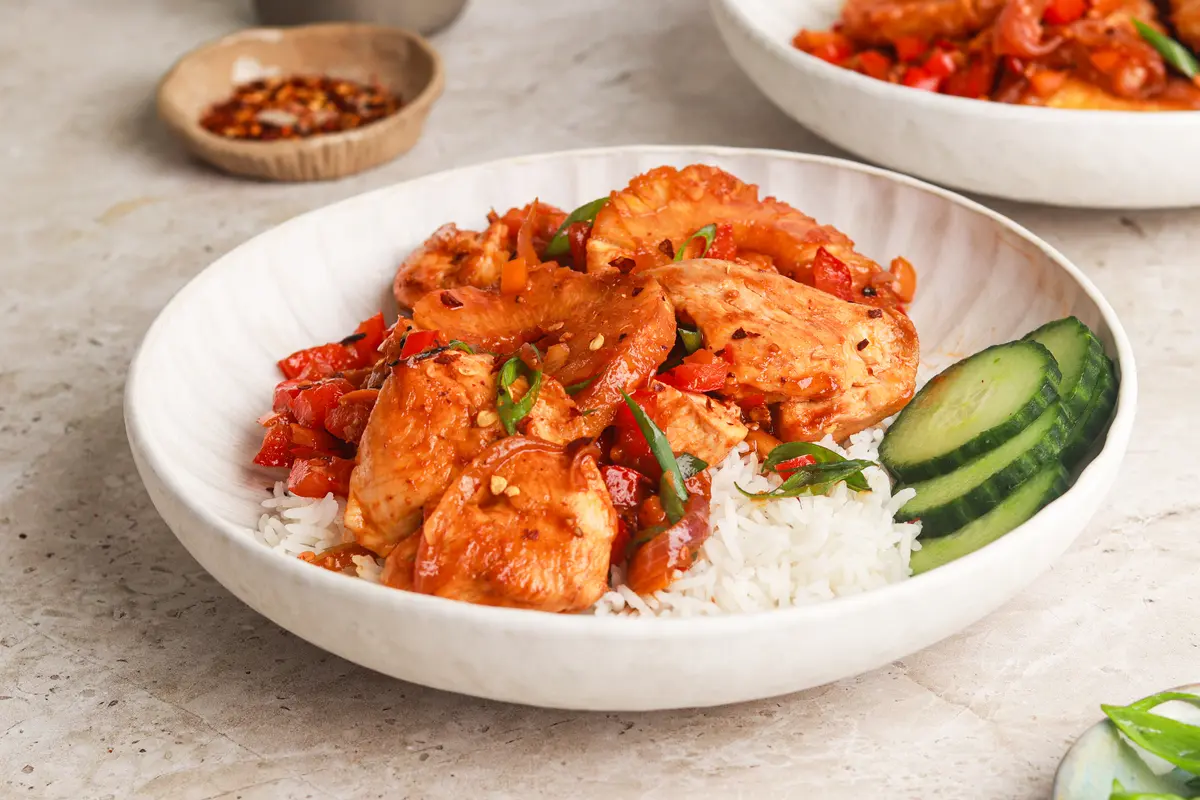 Hawaiian Chicken served with caramelised pineapple, peppers and rice in a ceramic bowl.