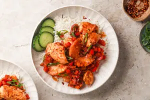 Overhead shot of Hawaiian Chicken with pineapple and rice garnished with cucumber slices