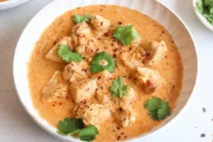 Slow cooker Thai red curry served with creamy coconut sauce and fresh herbs.