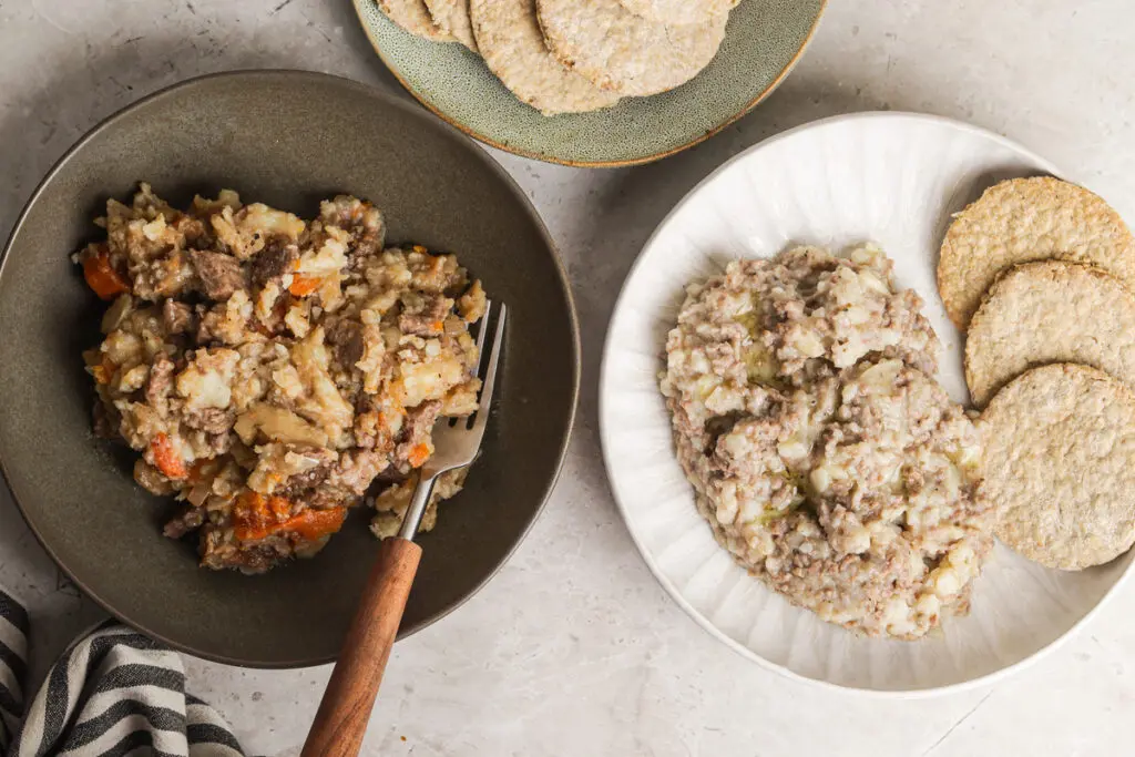 Two types of Scottish stovies served in bowls with oatcakes on the side