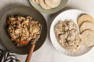 Two types of Scottish stovies served in bowls with oatcakes on the side