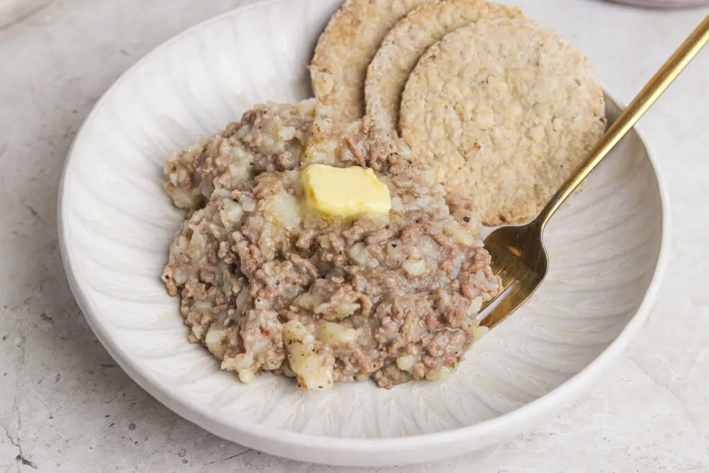 Bowl of mince stovies topped with butter and served with oatcakes