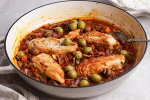 Close-up of Chicken Cacciatore with tender chicken breasts in a glossy tomato, mushroom and olive sauce