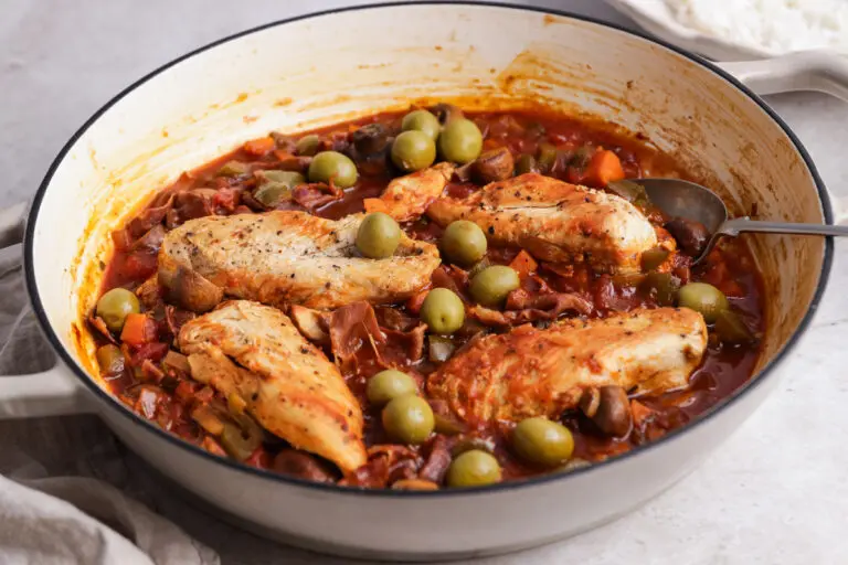 Close-up of Chicken Cacciatore with tender chicken breasts in a glossy tomato, mushroom and olive sauce