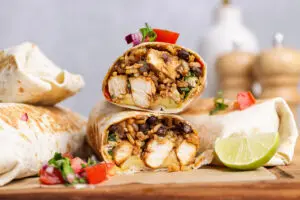 Close-up high-protein chicken burrito cut open showing rice and black beans