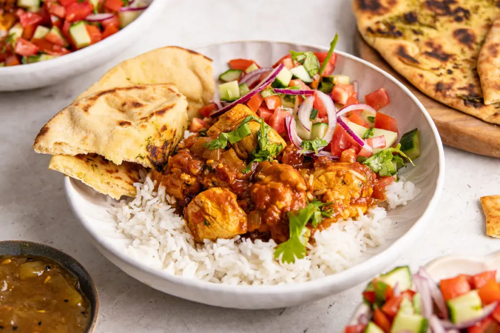 Close-up of high protein curry Chicken Madras with rice and coriander garnish