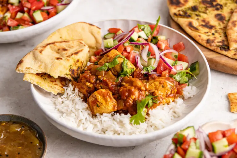 Close-up of high protein curry Chicken Madras with rice and coriander garnish