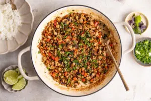 High-protein Thai basil pork stir fry cooking in pan with minced pork, peppers and spring onions