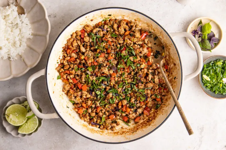 High-protein Thai basil pork stir fry cooking in pan with minced pork, peppers and spring onions