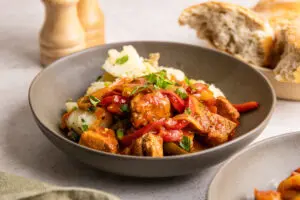 Close-up pork goulash with peppers in rich tomato paprika sauce