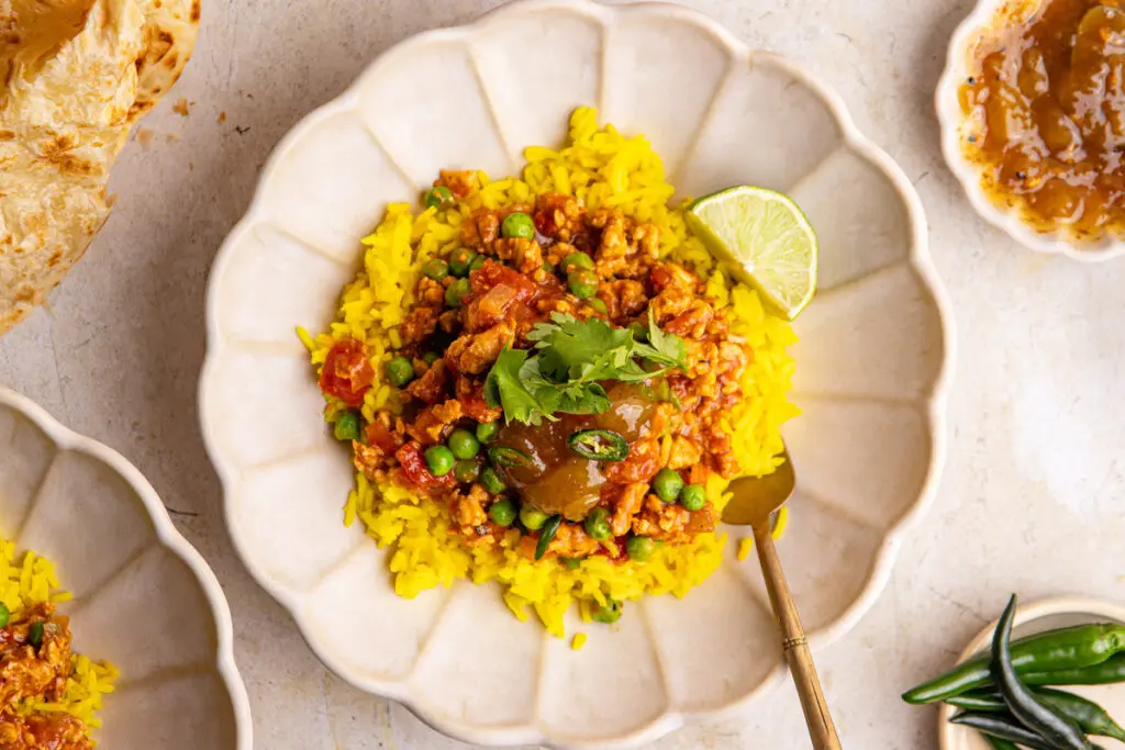 Chicken keema served over yellow rice with mango chutney and fresh coriander