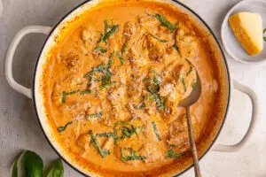 High-protein creamy paprika chicken in pan with parmesan and basil garnish