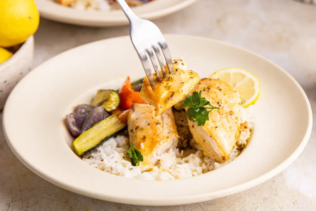 Juicy glazed chicken piece on fork showing texture and sauce coating
