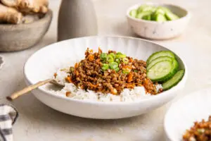 Korean beef mince bowl with rice and cucumber, topped with spring onions