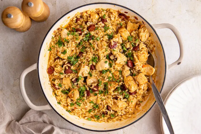 Creamy high-protein chicken and chorizo risotto in a large pan, topped with fresh parsley and smoky crispy chorizo slices.