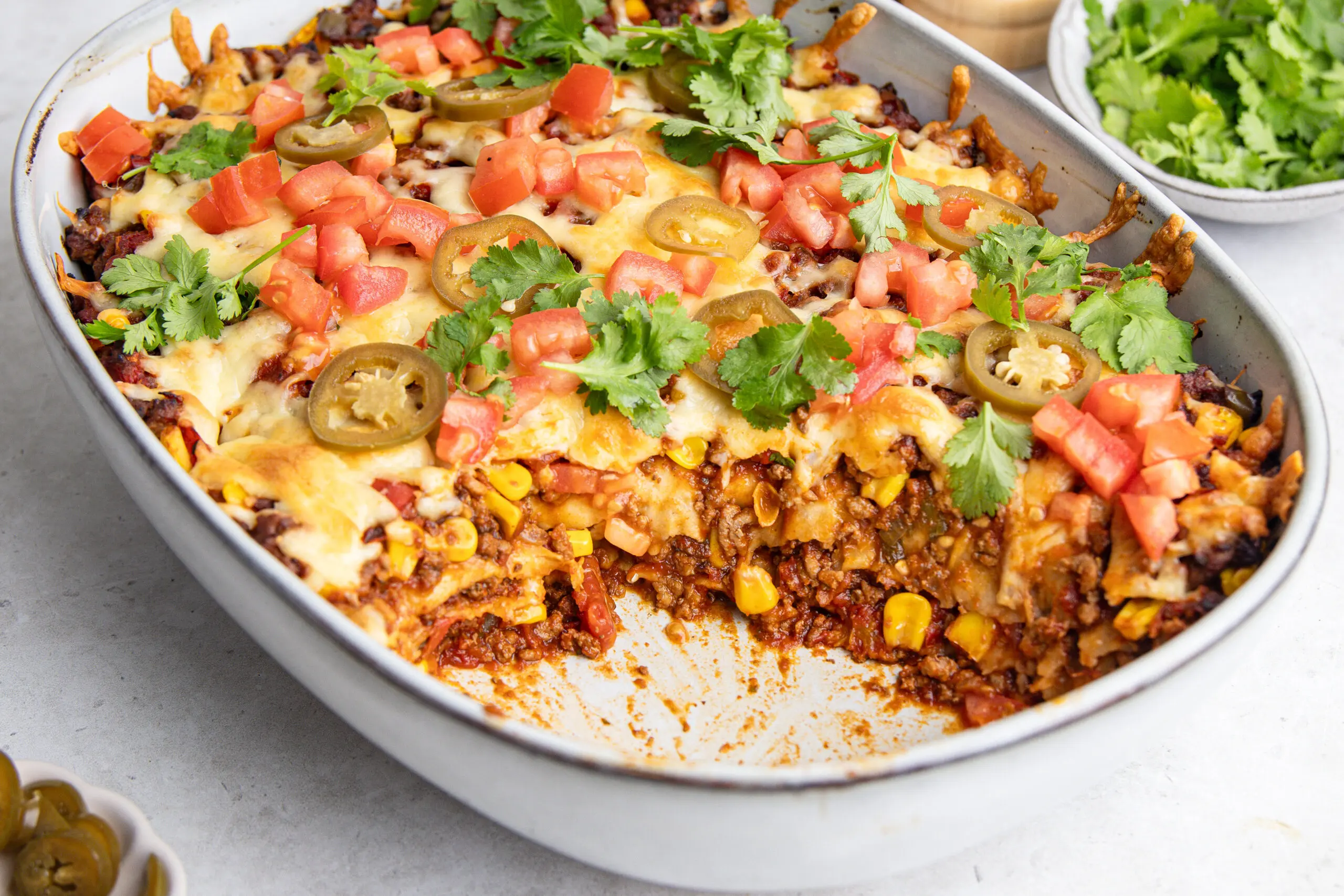 Mexican lasagne showing beef mince, sweetcorn, tortilla layers and melted cheese