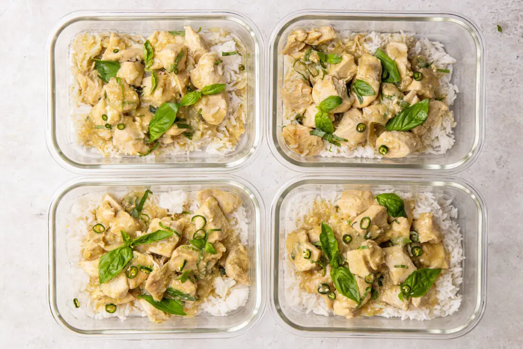 Meal prep containers filled with Thai green chicken curry, rice, basil and chilli