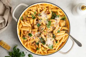 Overhead view of creamy chicken and chorizo pasta topped with Parmesan and fresh parsley.