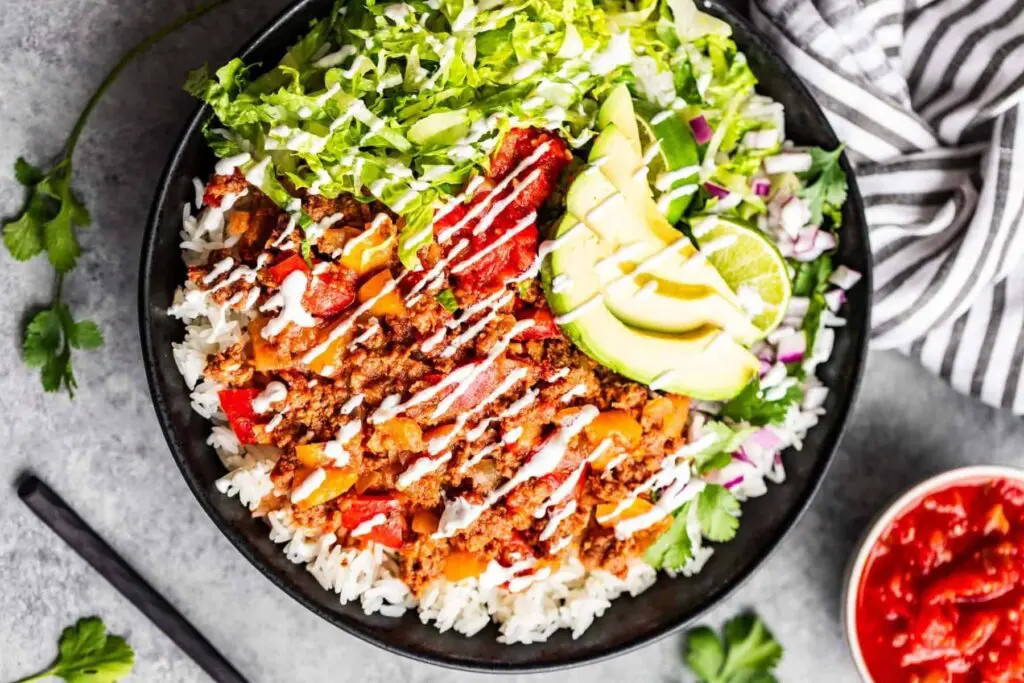Turn slow-cooked salsa beef mince into a colourful Mexican-style bowl with fluffy rice, crisp lettuce, avocado, lime and a creamy drizzle. It’s a fresh, filling slow cooker mince recipe that feels a bit more exciting than another bowl of chilli.