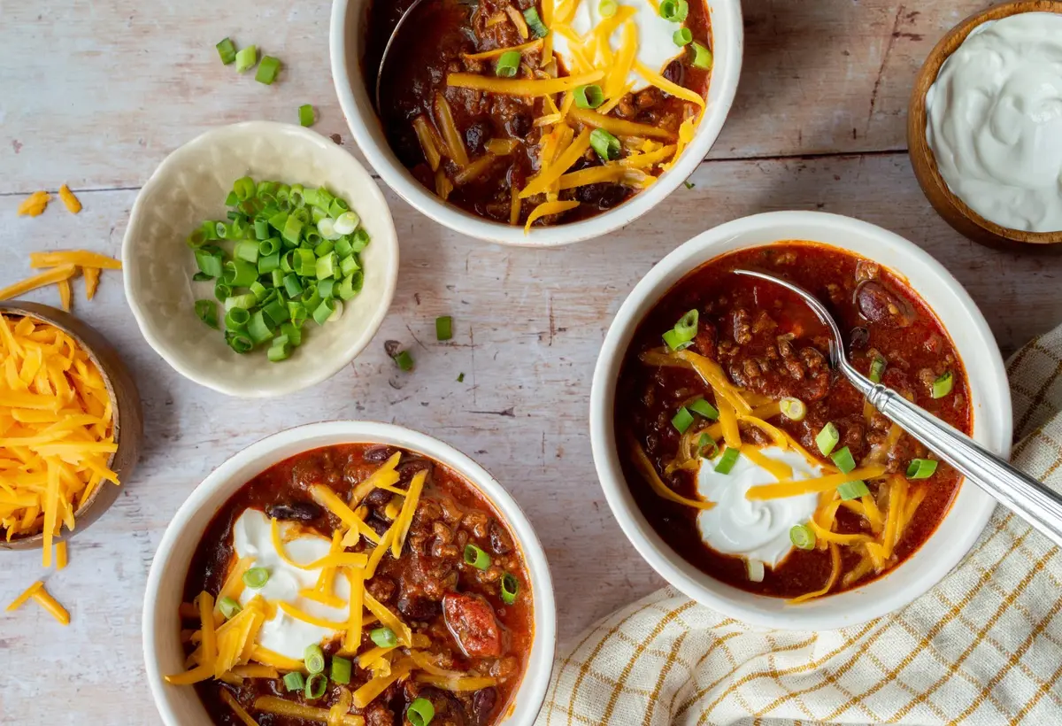 A classic slow cooker mince recipe featuring a thick, beefy chilli topped with grated cheese, sour cream and sliced spring onions. Simple, cosy and exactly the sort of dinner that tastes even better the next day.