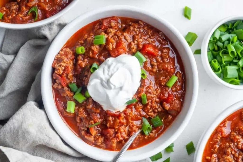 This hearty no-bean chilli is a meaty slow cooker mince recipe with a thick tomato sauce and plenty of warming spice. A dollop of sour cream and chopped spring onions cool everything down nicely.