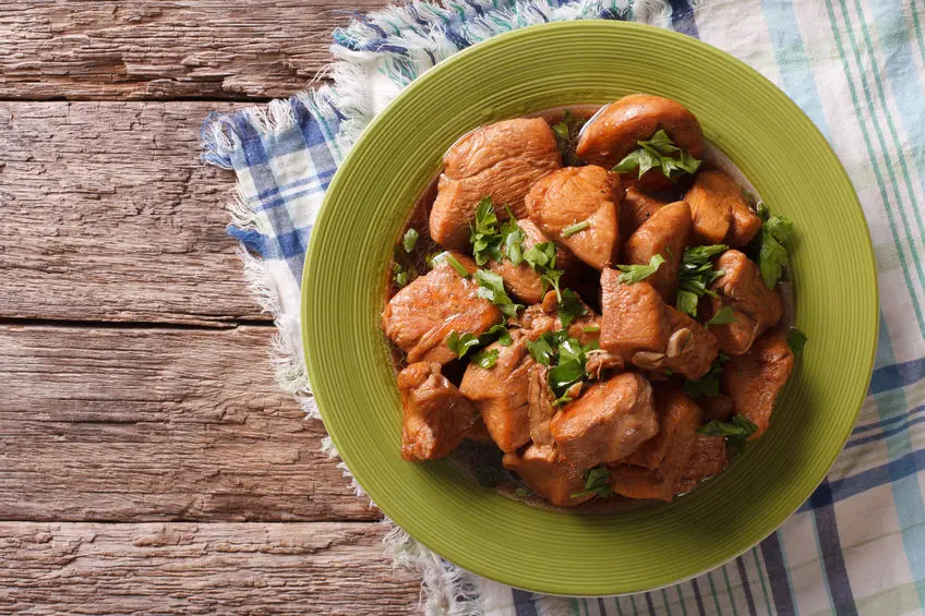 chicken in adobo sauce closeup on a plate on the table. horizontal view from above